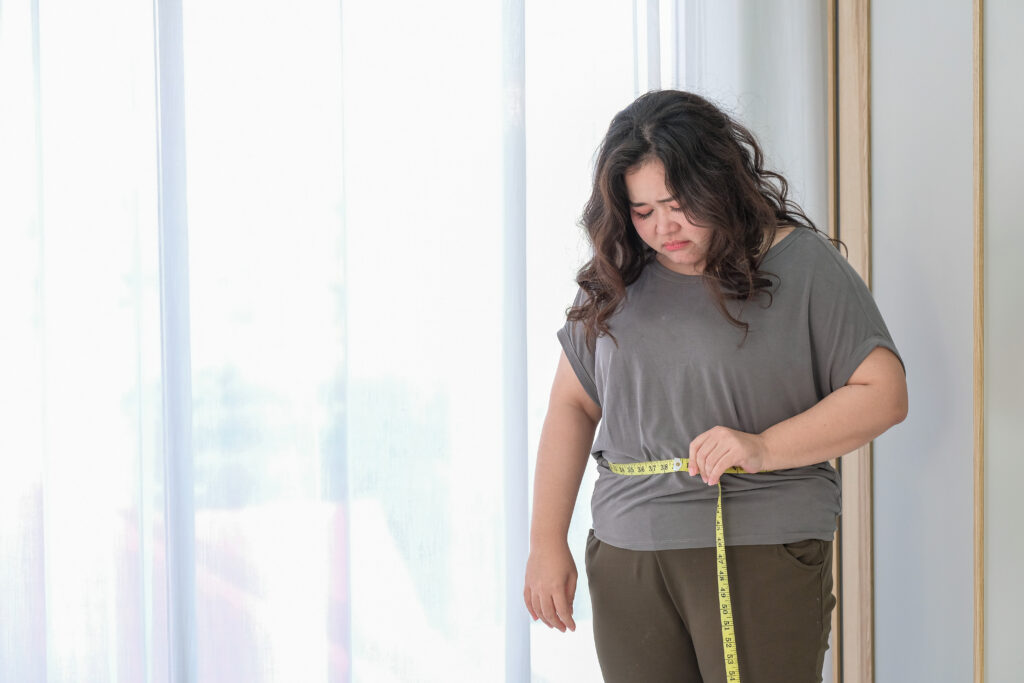 Woman checking herself with a tape measure